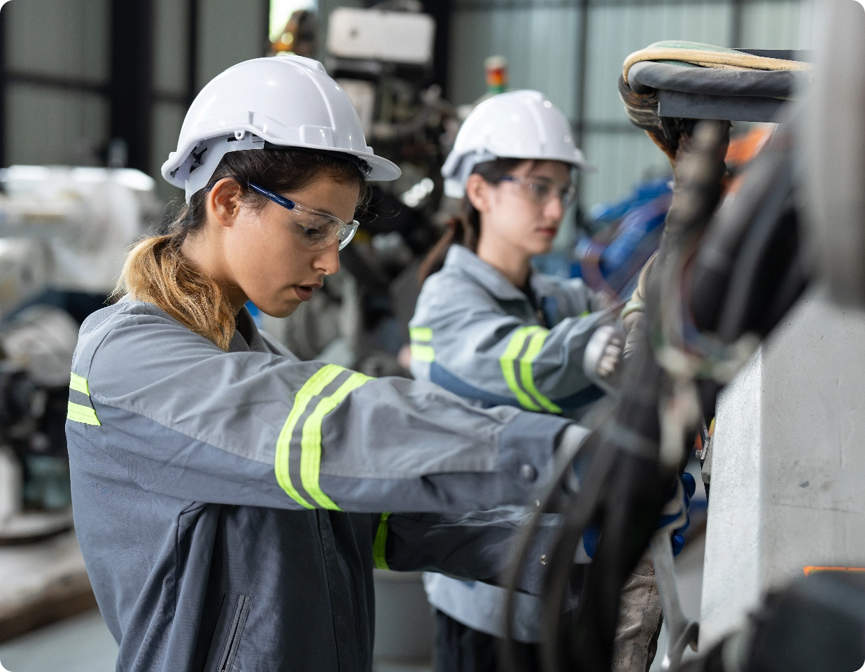 Techniciennes en maintenance sur un bras robotisé