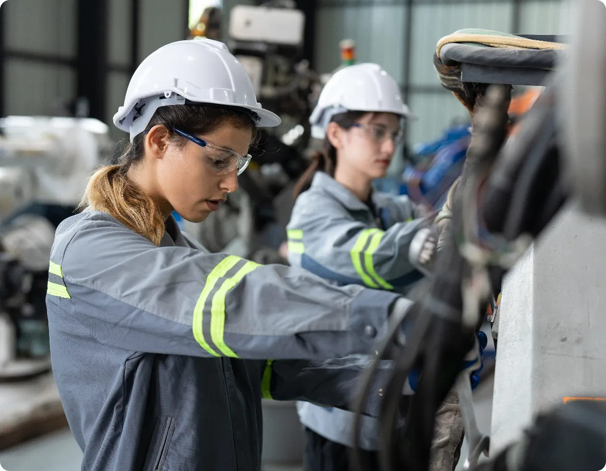 Techniciennes en maintenance sur un bras robotisé